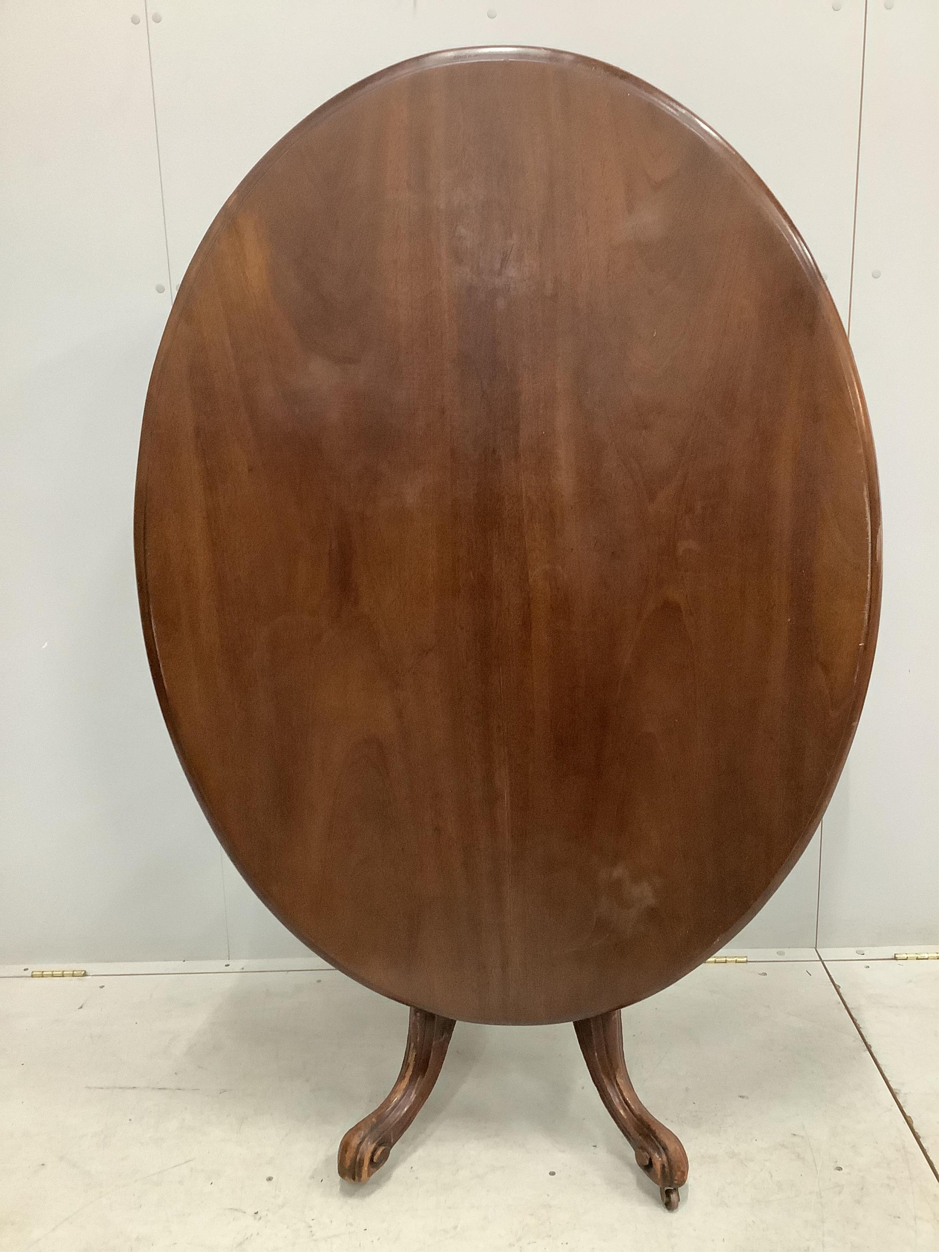 A Victorian mahogany oval tilt top breakfast table, width 135cm, depth 101cm, height 75cm. Condition - poor, some staining to the top